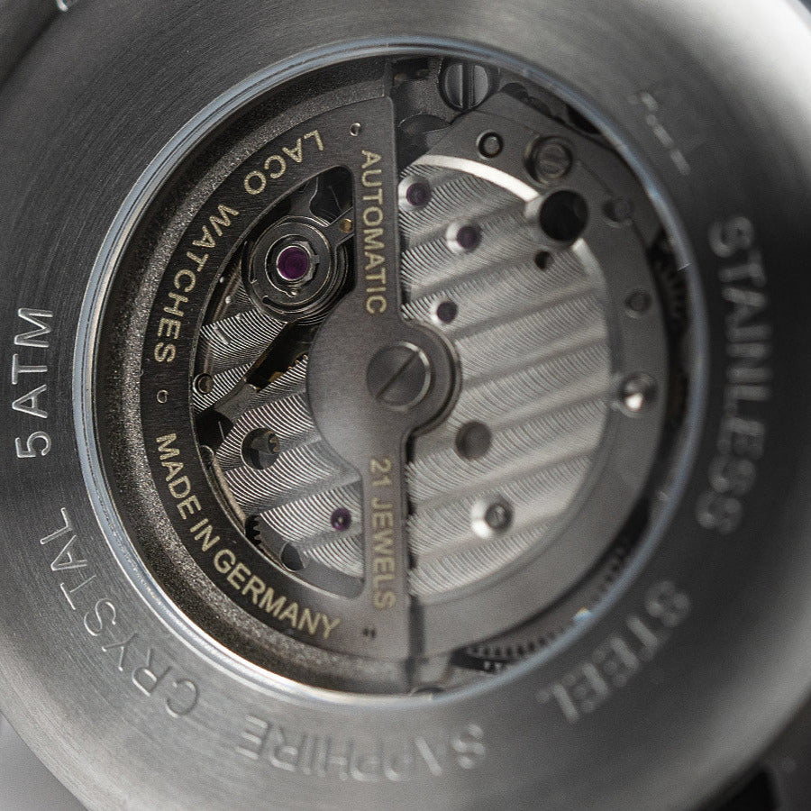 Close-up of a watch mechanism with 'Laco' branding on a dark background